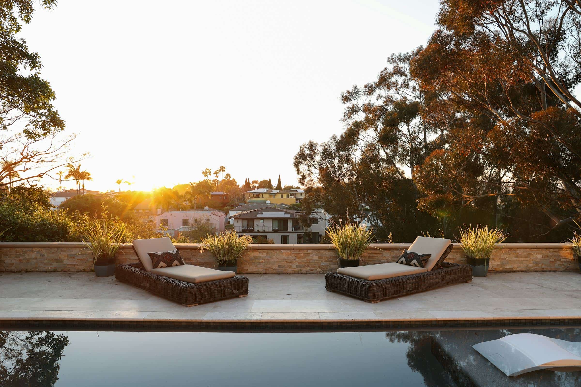 Pool terrace with planted retaining wall at golden hour