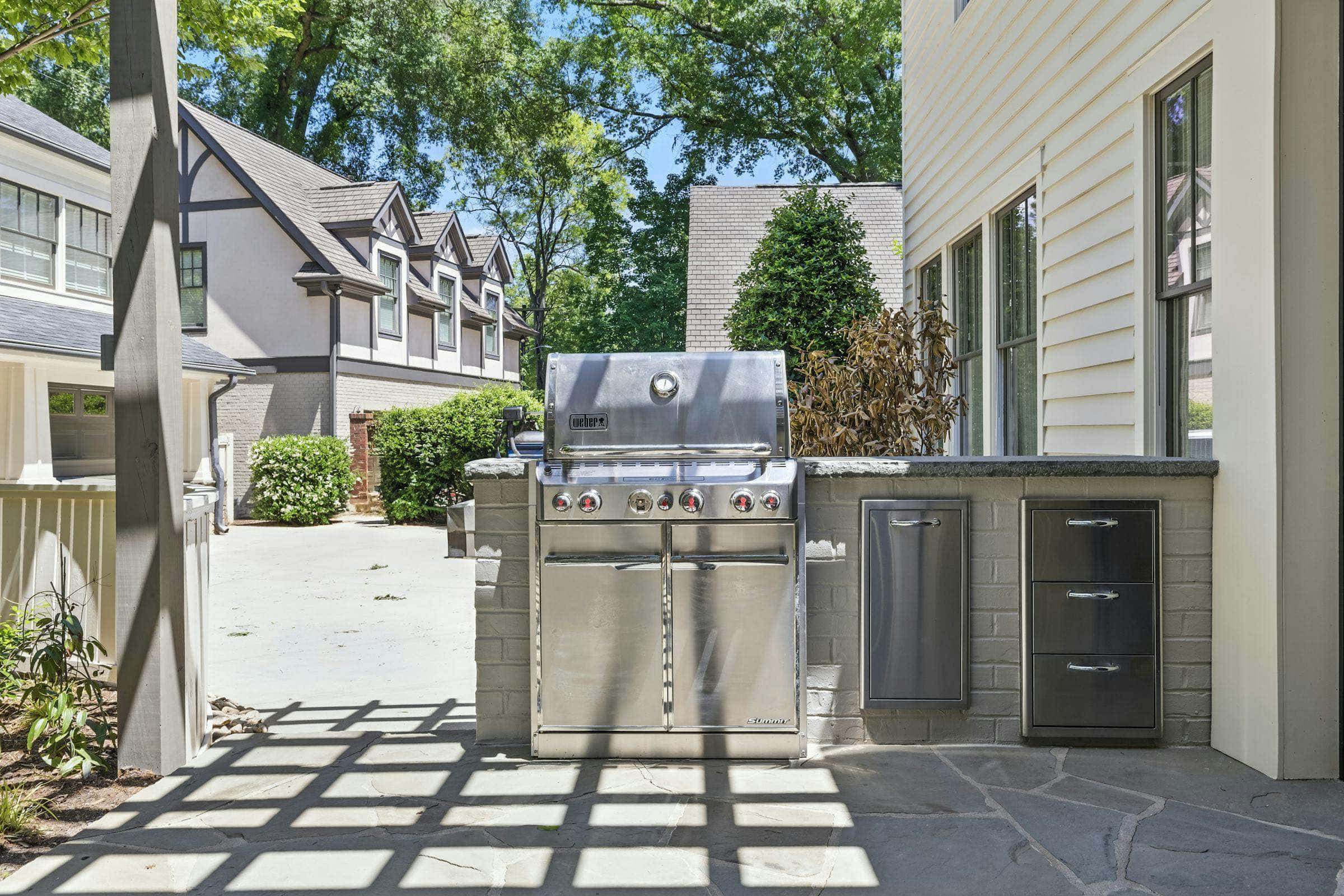 Built-in stainless grill with stone surround on a patio